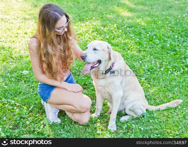 Girl playing with her labrador retriever dog in the park
