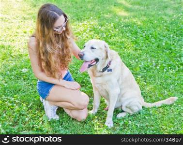 Girl playing with her labrador retriever dog in the park
