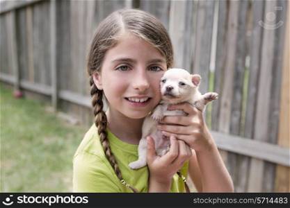 Girl playing with puppy chihuahua pet dog at the backyard