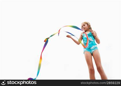 Girl playing with stick streamer low angle view