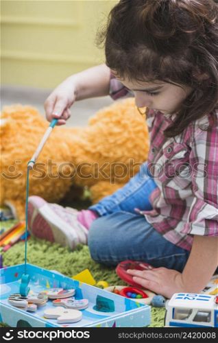 girl playing with toy fishing rod
