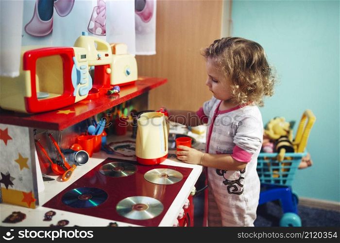 girl playing with toy kitchen
