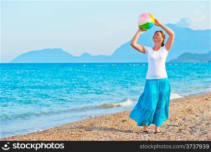 girl plays with a beach ball near the sea