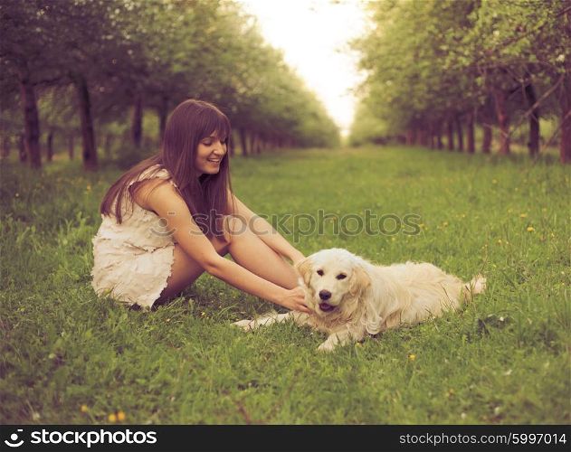 Girl plays with golden retriever in the park. Girl plays with dog