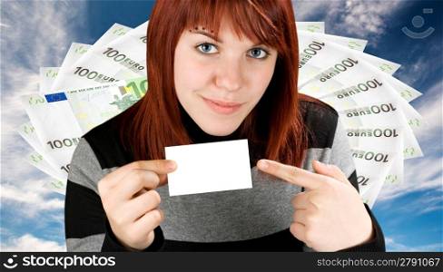 Girl pointing finger at a blank business card, smiling and cute. Concept success and wealth. Studio shot.