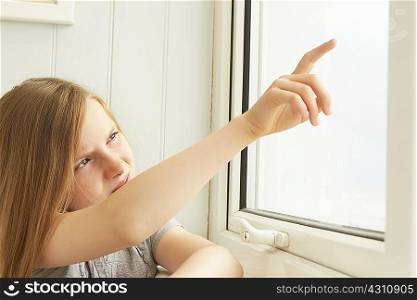 Girl pointing out of holiday apartment window