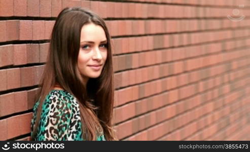 girl posing against a brick wall.