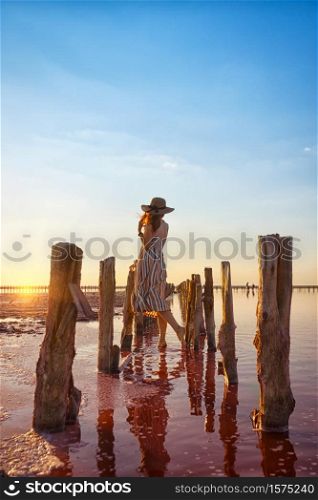 girl posing at sunset on the famous pink salt lake