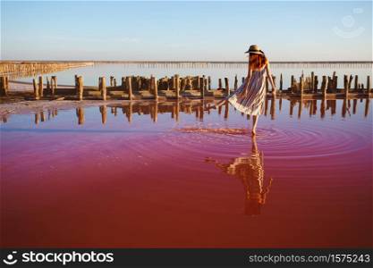 girl posing at sunset on the famous pink salt lake. reflection in the lake