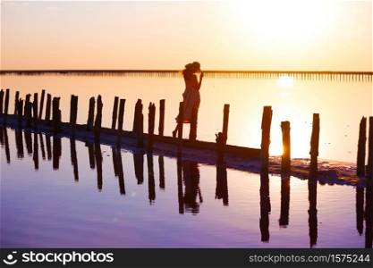 girl posing at sunset on the famous pink salt lake. reflection in the lake