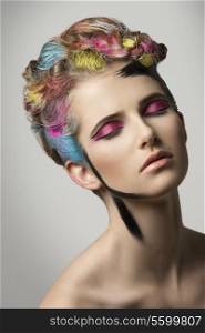 girl posing with relaxed expression in creative beauty portrait with multicolor painted hair-style and crazy make-up.