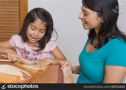 Girl preparing bread with her sister in the kitchen