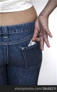 girl pulling out condoms from her jean pocket for Safe Sex concept
