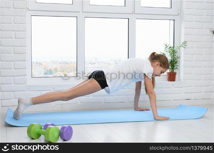 Girl push ups on sports rug at home