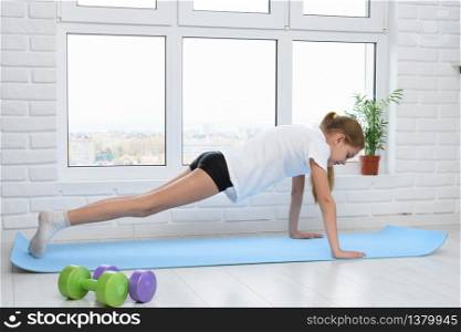 Girl push ups on sports rug at home