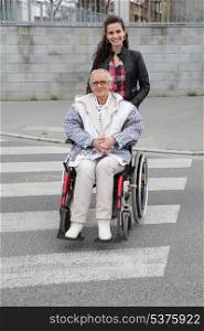 Girl pushing senior woman in wheelchair