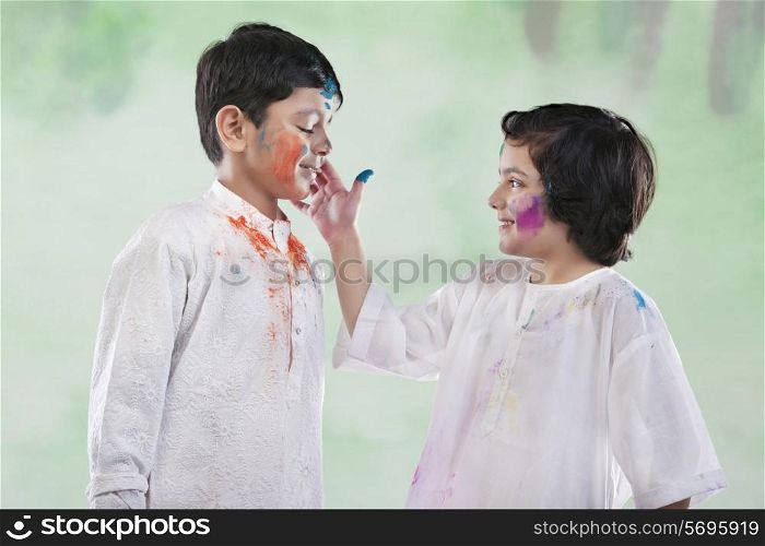 Girl putting colour on a boy