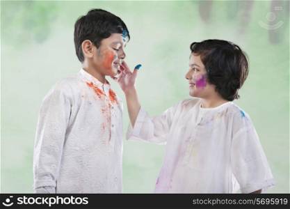 Girl putting colour on a boy