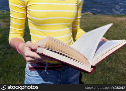 girl reading a book at the outdoors