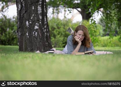 girl reading a book on the lawn