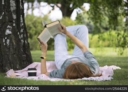 girl reading a book on the lawn
