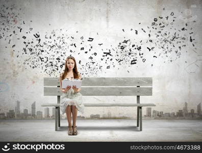 Girl reading book. Asian pretty woman sitting on bench and reading book