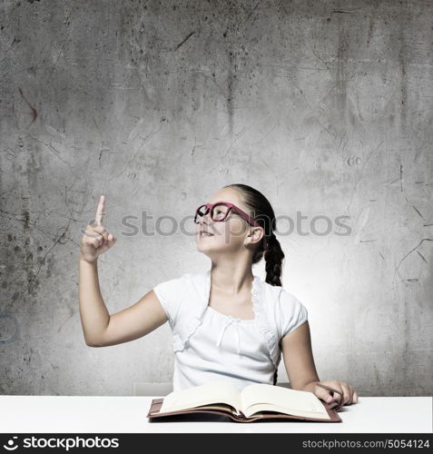 Girl reading book. School pretty girl in red glasses reading book