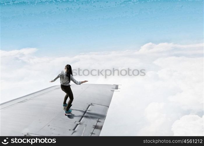 Girl ride skateboard. Active girl riding skateboard on airplane wing
