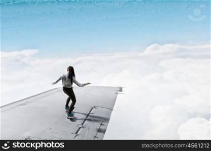 Girl ride skateboard. Active girl riding skateboard on airplane wing