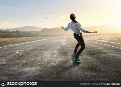 Girl ride skateboard. Active girl riding skateboard on asphalt road