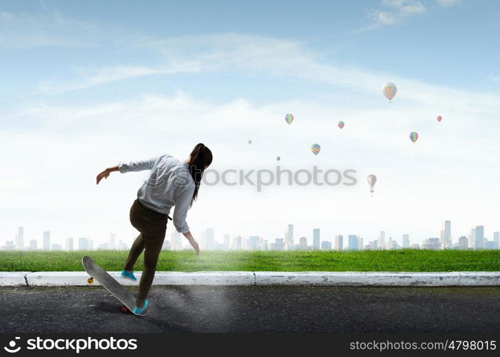 Girl ride skateboard. Active girl riding skateboard on asphalt road