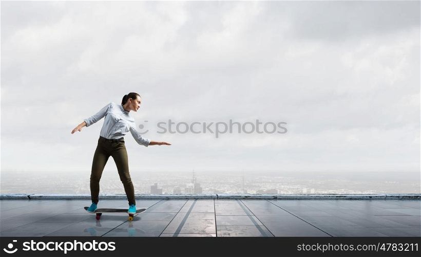 Girl ride skateboard. Active girl riding skateboard on building roof