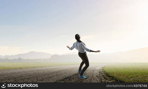 Girl ride skateboard. Active girl riding skateboard on countryside road