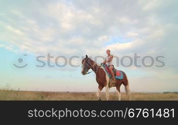 Girl rides a horse through the field