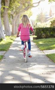 Girl Riding Bike Along Path