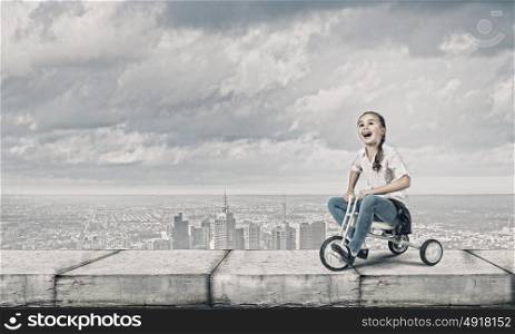 Girl riding bike. Little cute girl of preschool age riding tricycle