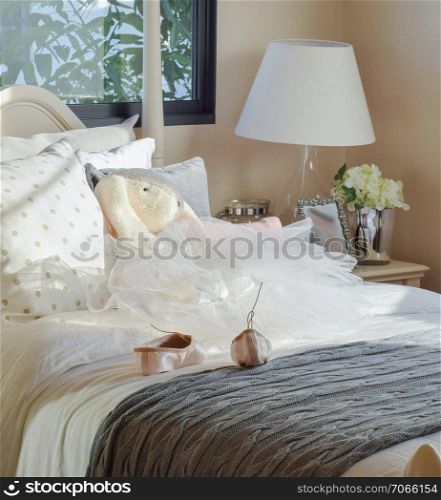 girl&rsquo;s bedroom with ballet shoes and dolls on bed at home