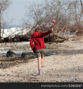 Girl running along Lake Winnipeg shoreline in Gimli, Manitoba Canada