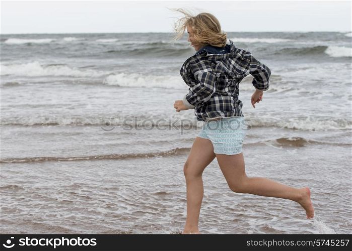 Girl running on the beach, Prince Edward Island, Canada