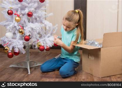 Girl shoots balls with Christmas tree. Girl shoots balls with Christmas tree and puts it in a box