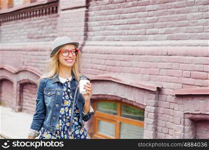 Girl shopping while travel . Happy tourist girl with coffee cup walking on city street