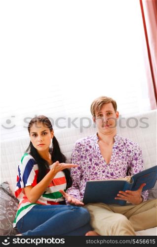Girl showing dissatisfaction with what she saw in the photo album &#xA;