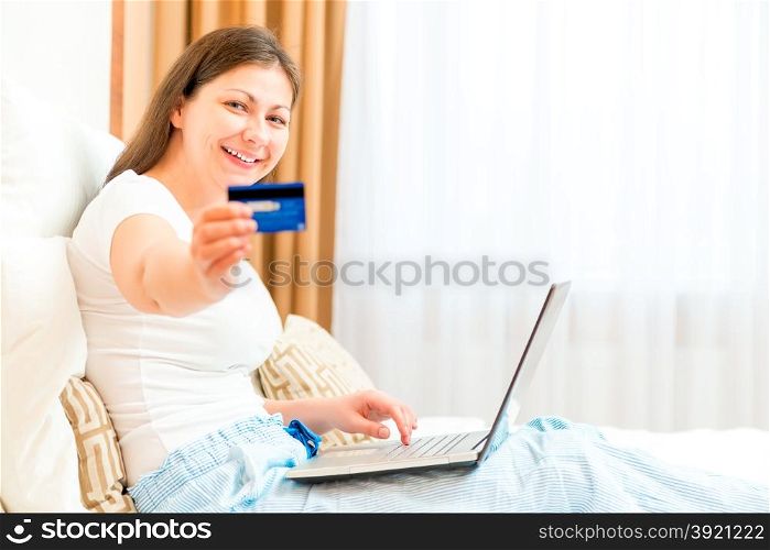 girl showing her credit card while sitting on the couch