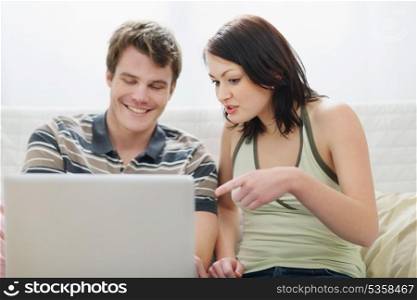 Girl showing to boyfriend something in laptop
