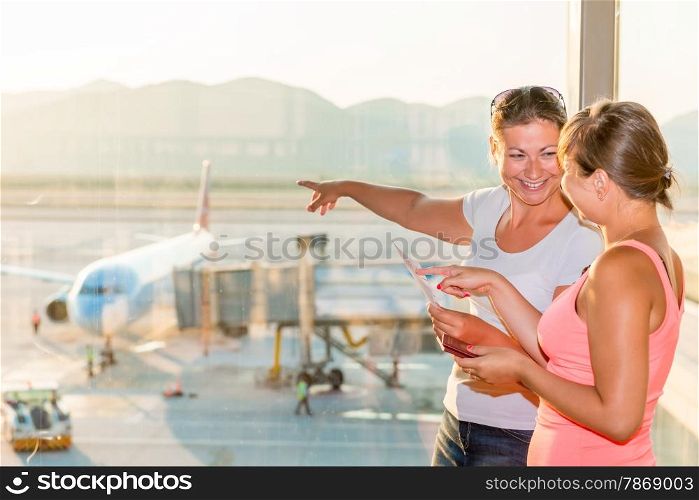 girl shows her friend a plane before take-off
