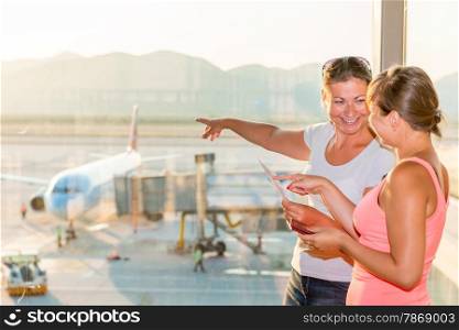 girl shows her friend a plane before take-off