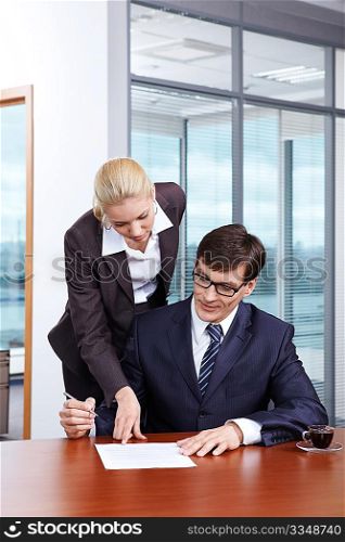 Girl shows the boss where to put the signature