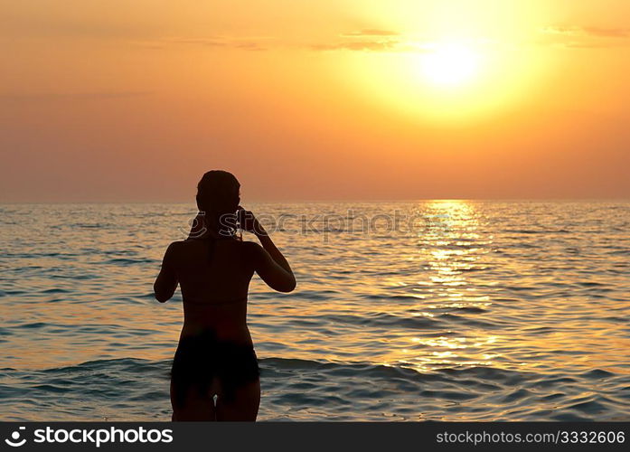 Girl silhouette and sunset on the sea