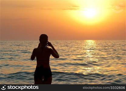 Girl silhouette and sunset on the sea