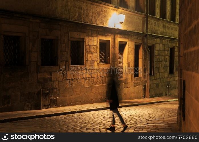Girl silhouette in motion on night illuminated street in Europe&#xA;